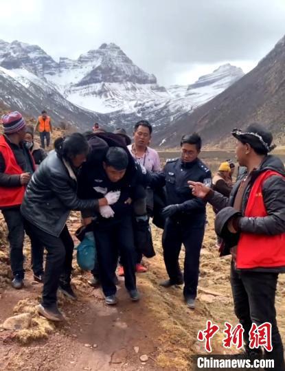 輔警洛絨洛珠(左三)背著楊某下山。德格警方供圖