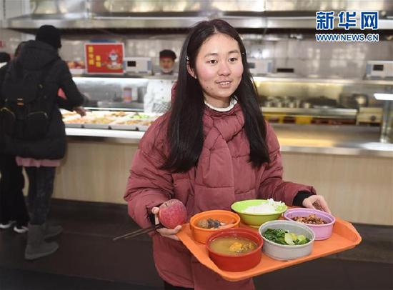 　1月24日，在四川大学望江校区北园餐厅，学生端着“一分钱年饭”准备就餐。新华社记者刘坤摄