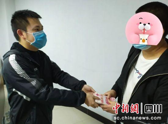 受害人從民警手中領被騙現金。 鐘欣 攝