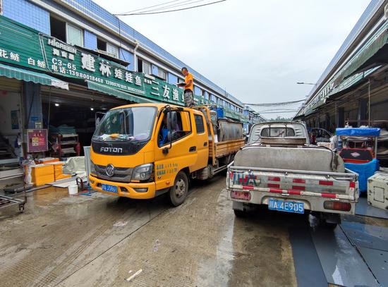 26日，成都白家市场内拉鱼的罐车堵满了街道