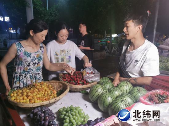 晚8時(shí)許,仍有不少市民在臨時(shí)便民攤點(diǎn)選購水果