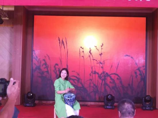 南充民建花鸟园林支部余芳表演的手鼓《打靶归来》