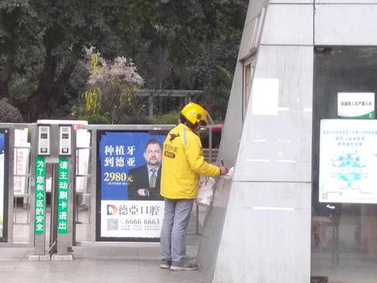 2月28日,一名外卖员在“上品拾陆”小区门口登记。