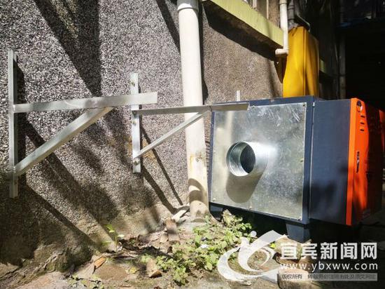 油烟净化器准备安装在居民厨房外墙的楼道上。(宜宾新闻网 曾江 摄)