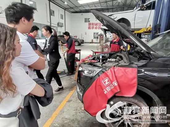 楊女士和丈夫張先生在看技師檢查車。記者 何東 攝