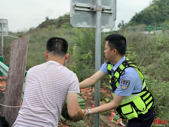 　↑交警帮忙将未摔烂的西瓜装上车。