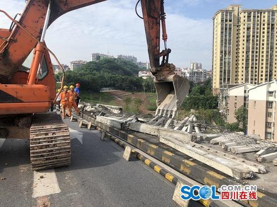 　7月2日上午，挖掘机正在对泸州长江大桥南引桥护栏就行拆除。陈向前 摄