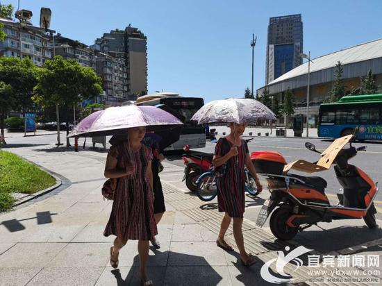 女士們打傘上街。(宜賓新聞網 楊萬洪 攝)