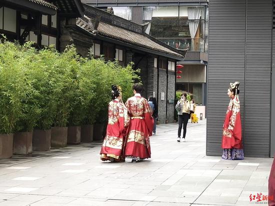 现场身着传统服饰的游客正在录制视频