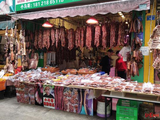 ▲新開寺街的商家門前掛滿了香腸臘肉
