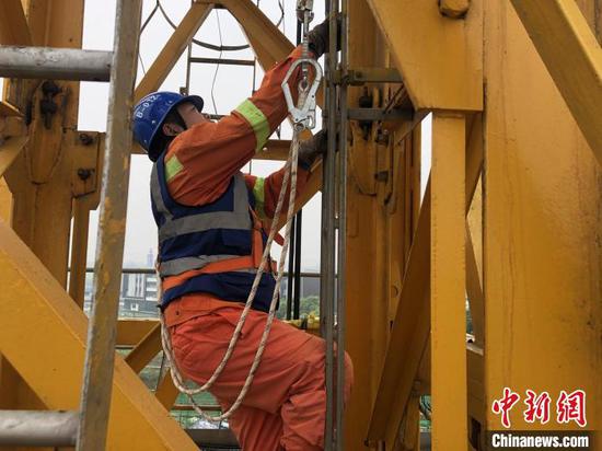 段天明在攀爬塔吊。 陳卉 攝