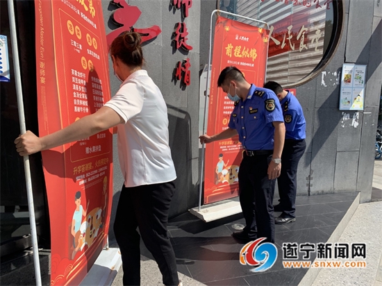 城管執法人員整治占道廣告牌。