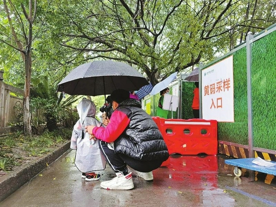 　11月6日，成都市第五人民医院志愿者张茂昇（右）在黄码采样入口外陪伴等待妈妈做核酸检测的小朋友。
