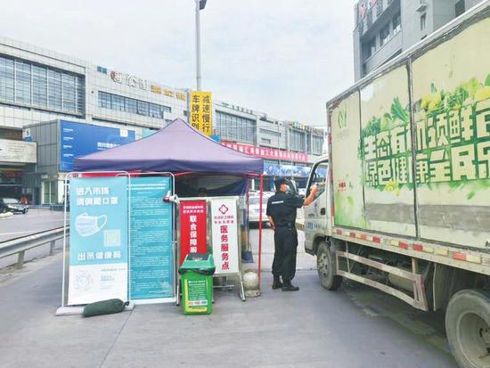 6月30日上午,成都雙流區白家農產品批發市場,入口處正在監測來往人員體溫。