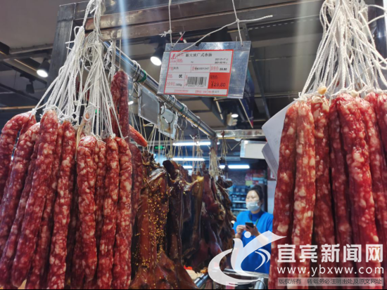 腊肉香肠“货卖堆山”,年味足。(记者 何东 摄)