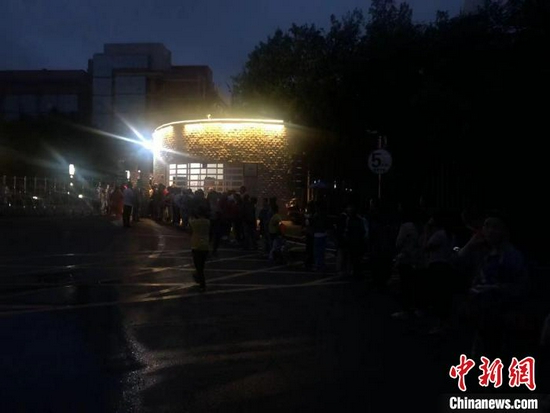安置點門口,民眾正在排隊等待登記。 賀劭清 攝