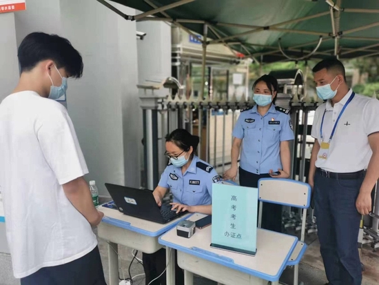 考生正在鄰水縣實驗中學考點外“高考學生臨時身份證服務點”辦理臨時身份證。