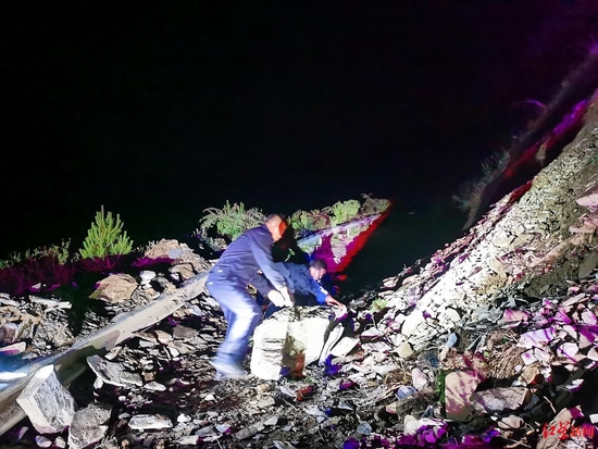 路遇塌方,劉松茂和同伴下車搬石頭開路