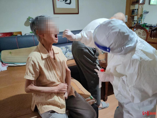 換上隔離衣的醫護人員上門進行核酸采樣