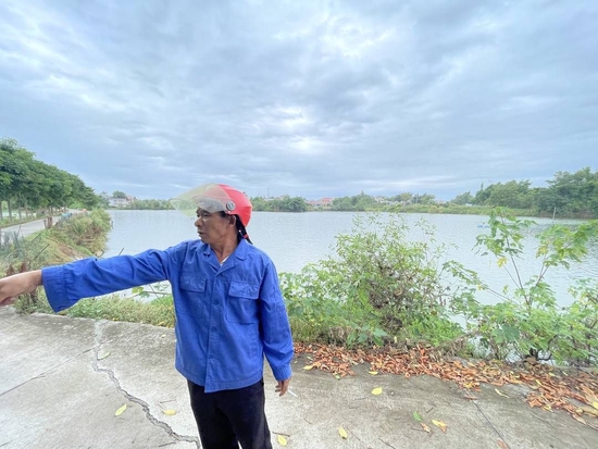 李光先在鱼塘边介绍情况