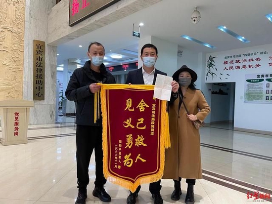 ↑陽和平夫妻給救命恩人段鴻(中)送錦旗和感謝信
