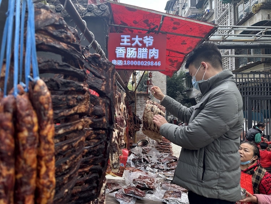 　市民正在采购香肠腊肉。