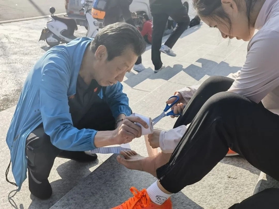 王金富教练为受伤队员杨璐桔打绷带