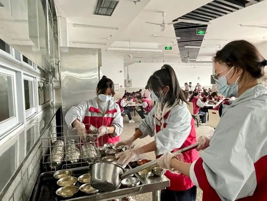 在食堂岗位的同学为其他同学盛汤