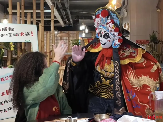 ▲意大利游客在火锅店观看川剧变脸表演，与演员互动