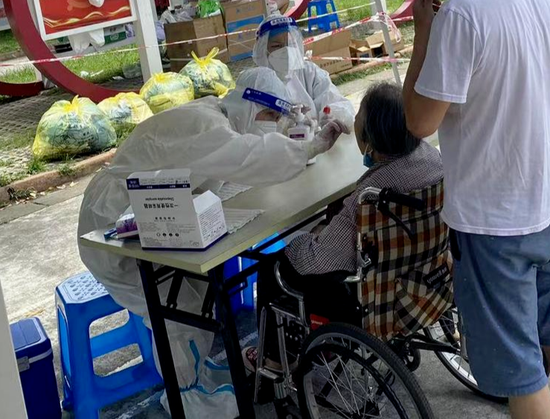 換上隔離衣的醫護人員正在進行核酸采樣