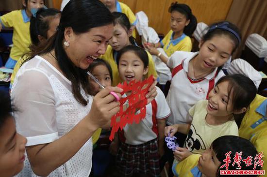 五一路小学校长何晓燕现场教孩子们学剪纸艺术