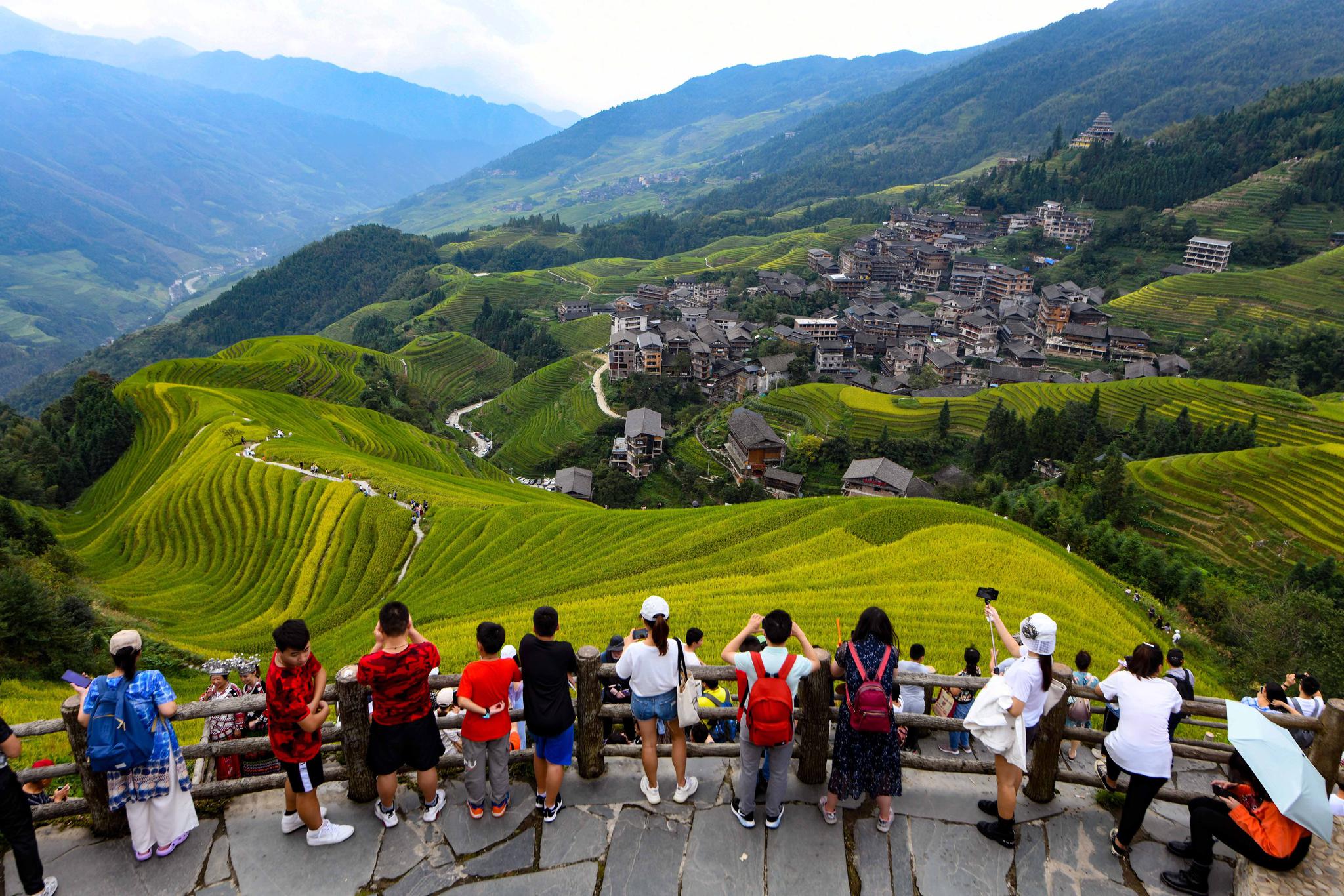 10月3日，游客在广西龙胜各族自治县龙脊梯田景区观光游玩。新华社发（吴生斌 摄）