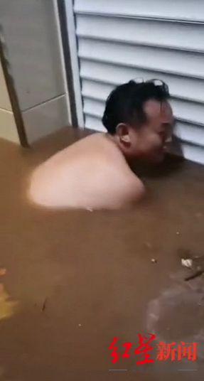 一居民试图在洪水中打开被淹的卷帘门