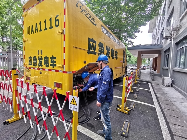 6月5日,都江堰树德都外高考考点,电力工人将应急发电车接入学校配电箱内,作为学校备用电源,确保高考期间学校正常用电。