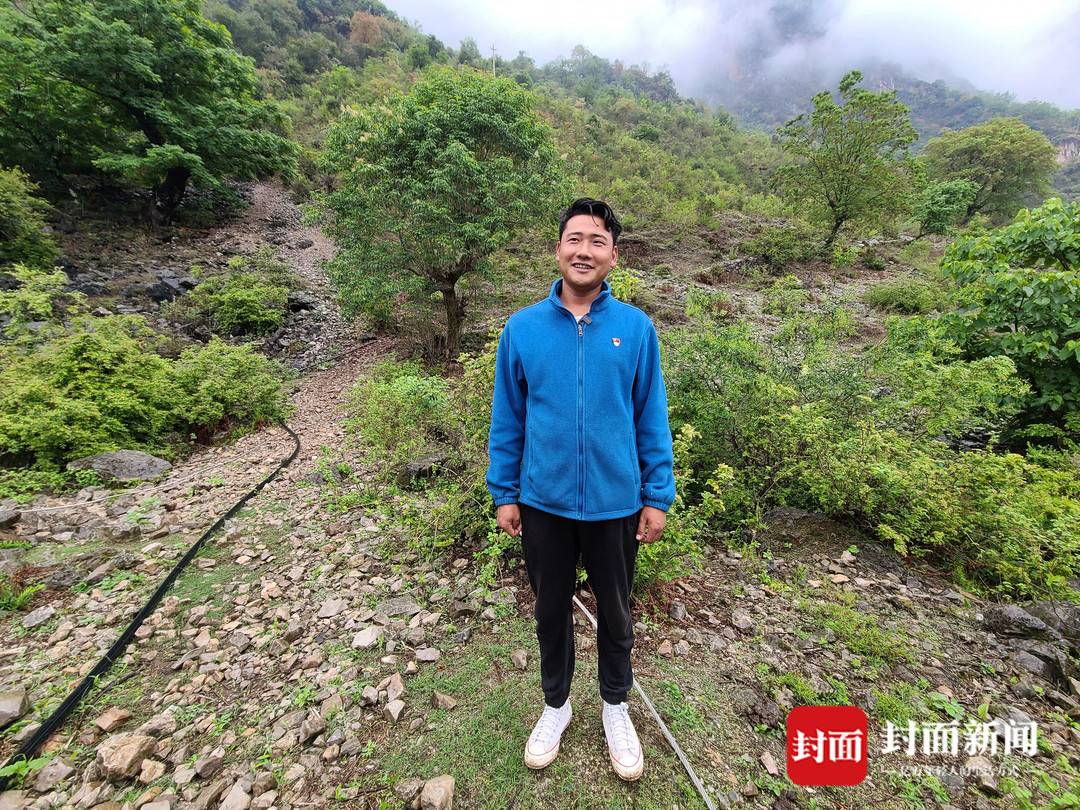 阿布洛哈村支部書記吉列子日,他身后是村里的老路