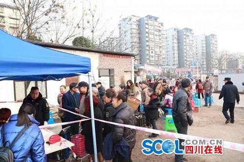 熏制点现场，市民依序排好队，等待将带来的腊肉香肠进行排号熏制。周梦颖摄。
