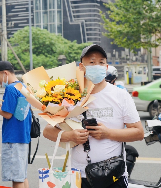 成都市第八中学考点外，家长捧花迎接考生。魏冯 摄