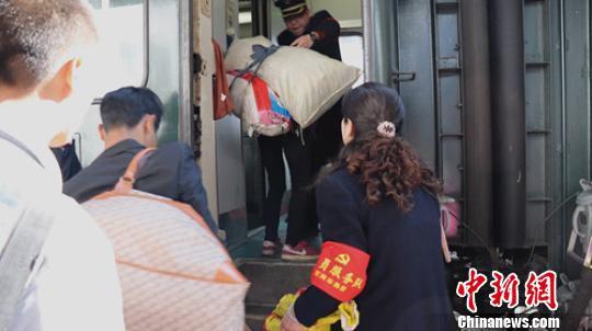 夫妻在同一车门协助旅客上车。 曾江 摄