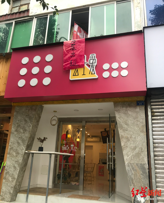 周女士租用的商铺招牌与二楼住户