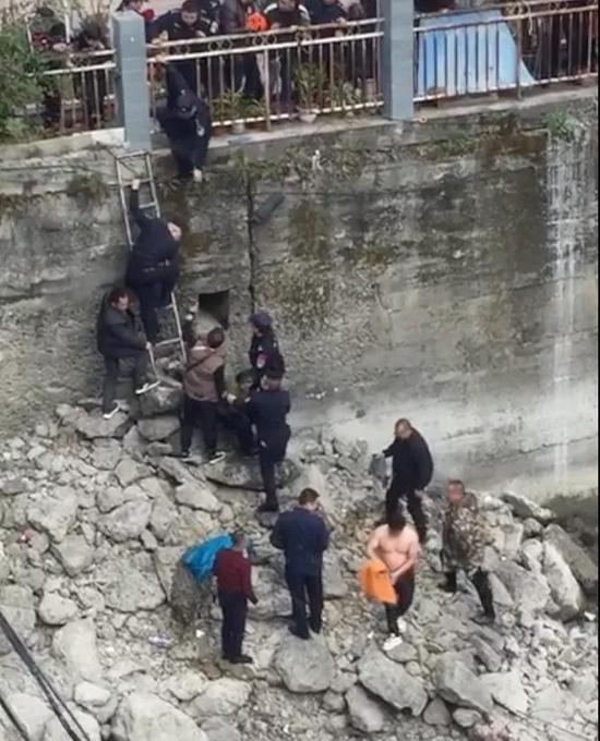↑在现场，人们准备通过梯子将被救起的落水女子送往医院
