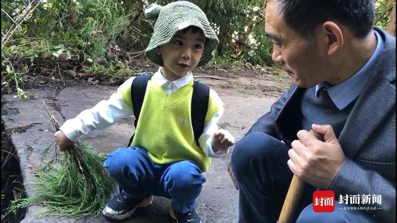 10月1日,5岁的杨哲睿和家人在山石上看“鸡脚印”