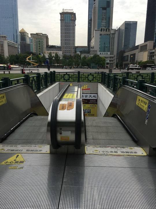 乘客拿着行李箱走下楼梯