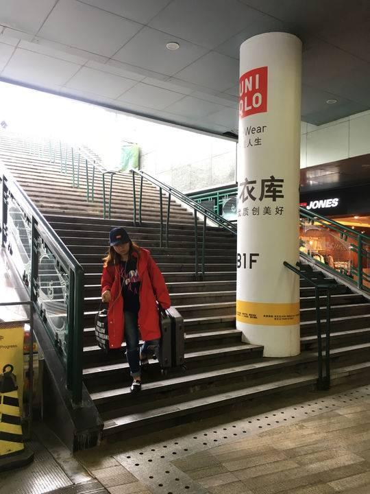 乘客拿着行李箱走下楼梯