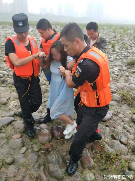 ▲民警趁其不备跳入江中将轻生女子救起