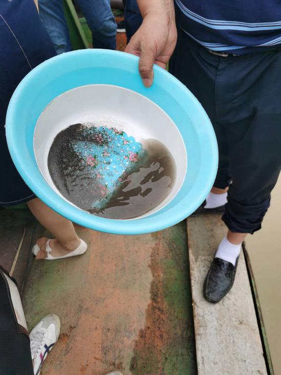 工作人員在現(xiàn)場調(diào)查,倉內(nèi)水靜置后出現(xiàn)沉淀。受訪者供圖