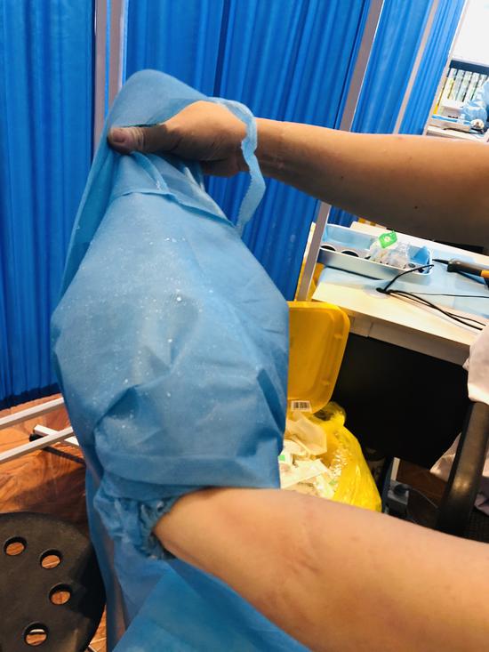 锦江区沙河街道新冠疫苗临时接种点，护士罗久萍的隔离服已是大汗淋漓。李燕欧摄。
