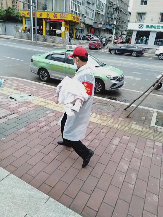防疫志愿者胡福偉抱著小女孩跑向出租車