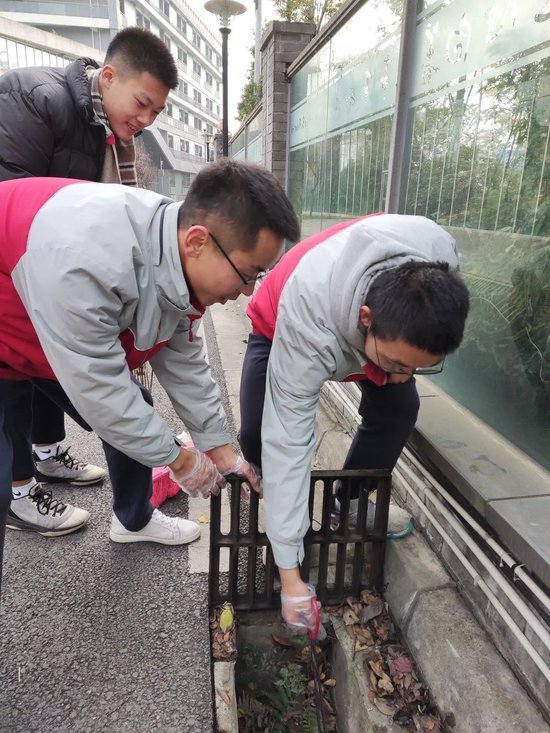 同学们清洁下水道的垃圾