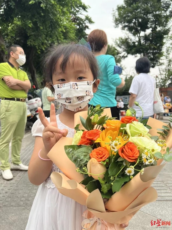 ▲5歲妹妹守在考場(chǎng)外為哥哥送花