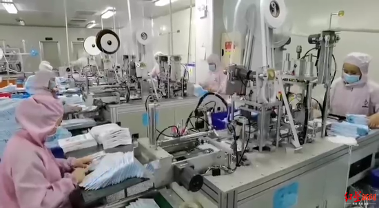▲除夕夜,新津事豐醫(yī)療器械有限公司內(nèi),工人們正加班加點(diǎn)生產(chǎn)口罩